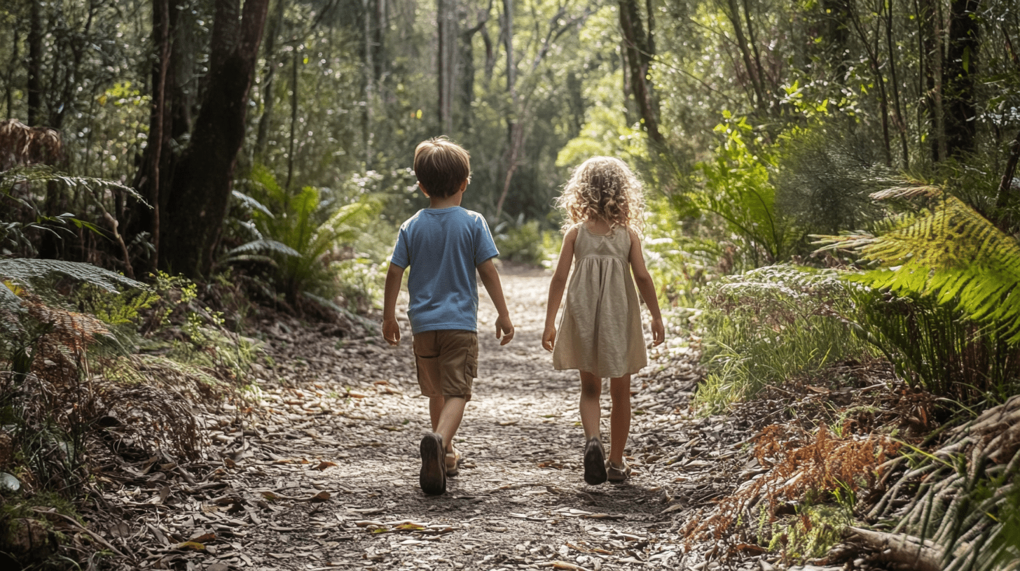 Two young children walking down a trail at a nature reserve in Toormina.