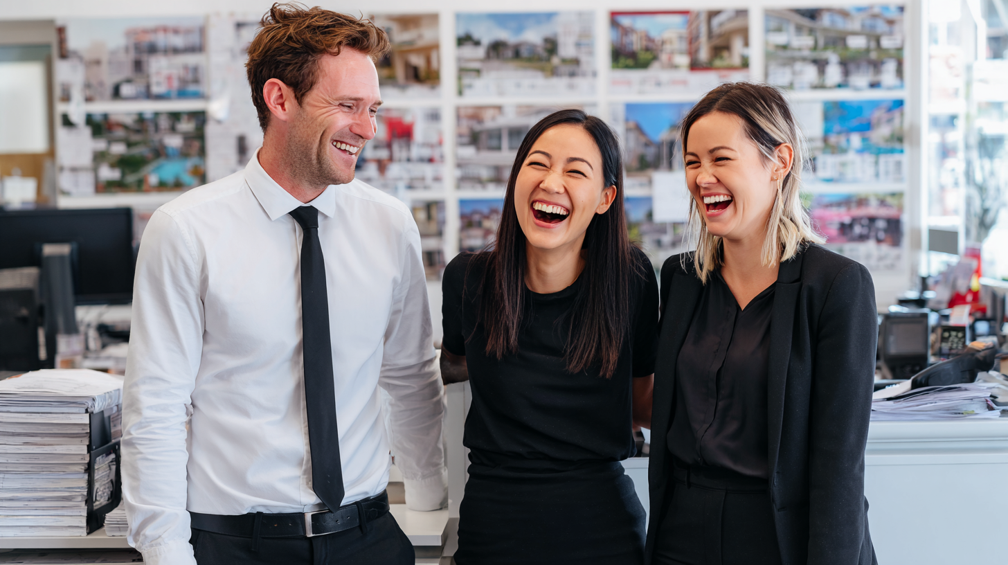 Three real estate agents standing in their office and celebrating SEO success.